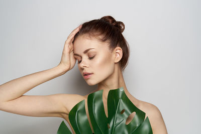 Portrait of young woman against white background