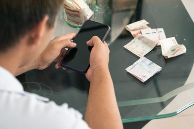 Man doing online shopping, bad financial situation, guy texting on his mobile phone, banknotes 