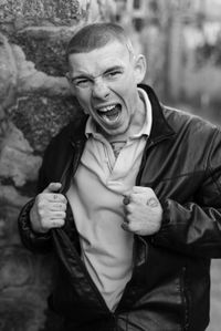 Portrait of man holding camera while standing outdoors