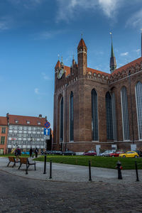 People on building against cloudy sky