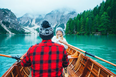 Woman smiling by lake against mountains