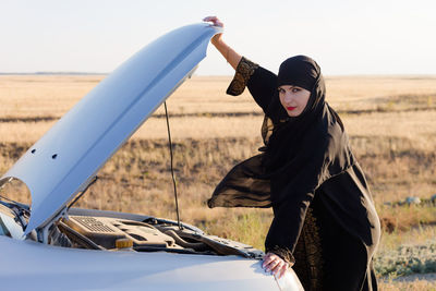 Islamic woman driver owner of car at open door. traditional islamic clothing