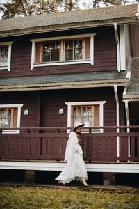 Bride walking against house