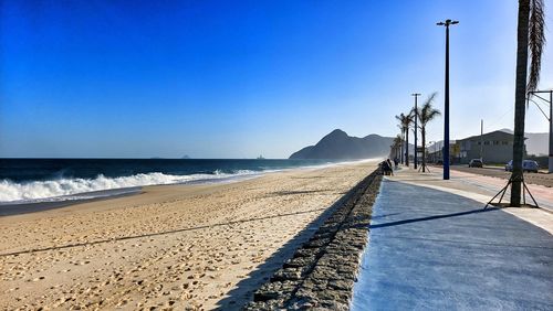 Scenic view of beach against clear blue sky