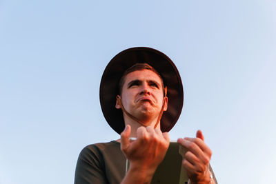 Portrait of young man against clear sky