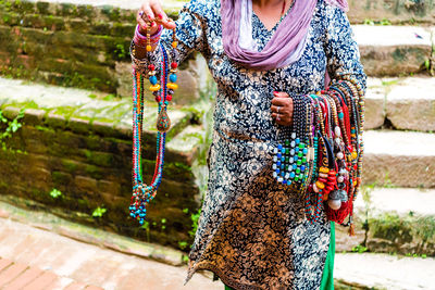 Midsection of woman holding multi colored umbrella