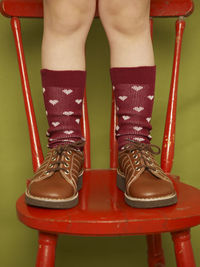 Child standing on chair, low section