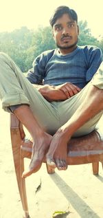 Portrait of young man sitting on chair