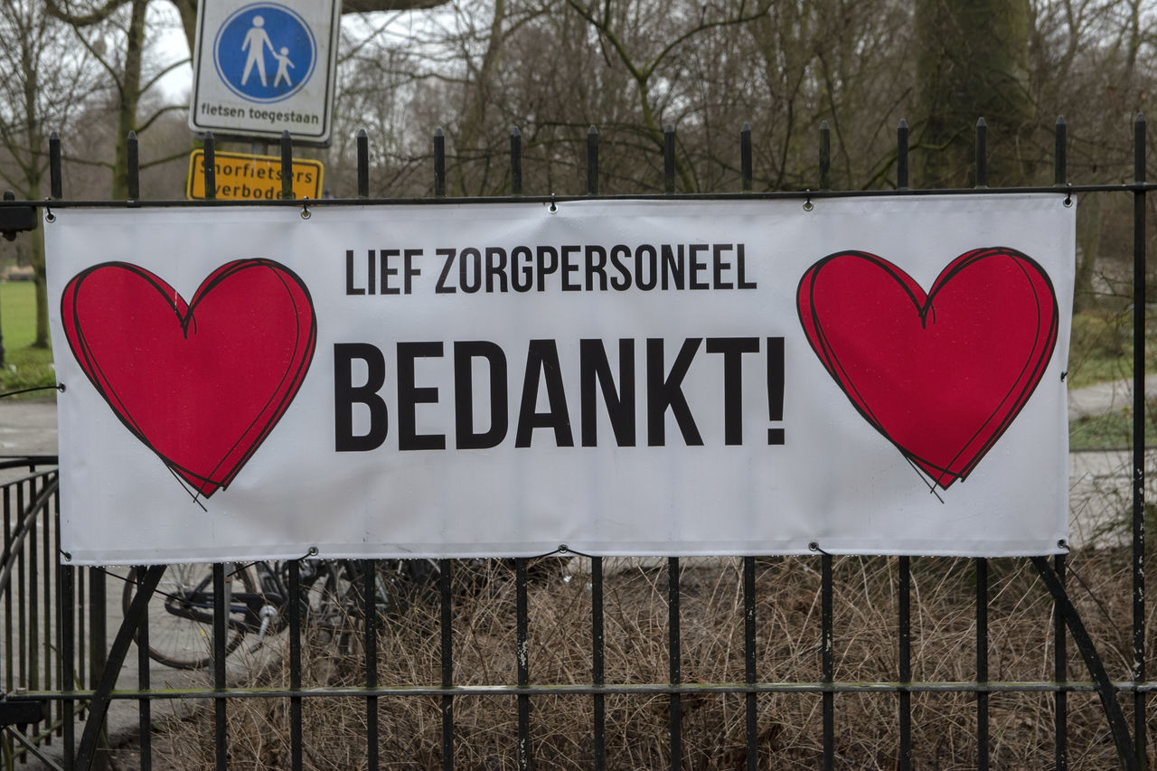 CLOSE-UP OF TEXT ON HEART SHAPE SIGN ON GROUND