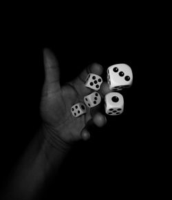 Close-up of human hand with tattoo on black background