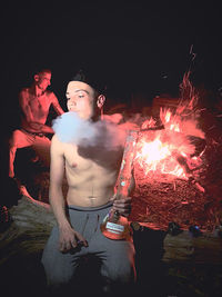 Young man with fire crackers at night