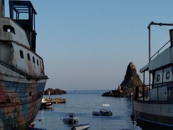 Boats sailing in sea against clear sky