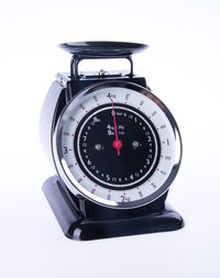 Close-up of old-fashioned weighing scale against white background
