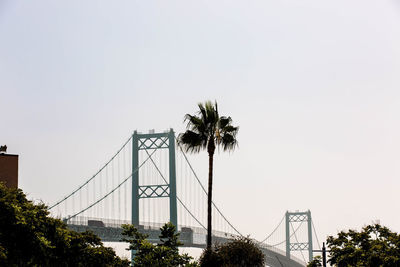 Low angle view of suspension bridge against sky