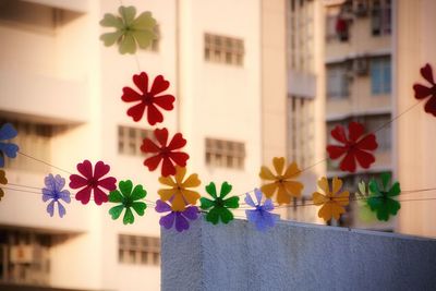 Close-up of floating wind-chimes against residential buildings. 
