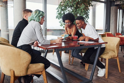 Group of multi ethnic people with alternative girl with green hair is working together