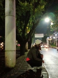 People sitting on footpath at night