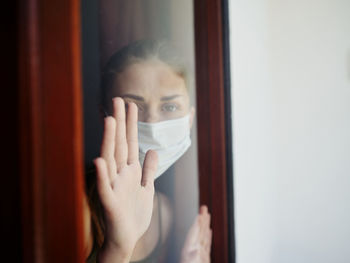 Portrait of woman hiding behind window