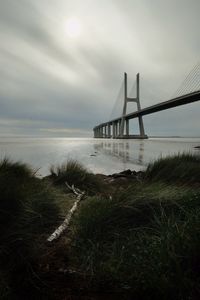 View of bridge over sea against cloudy sky