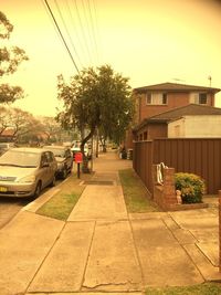 Cars on street by buildings in city against sky