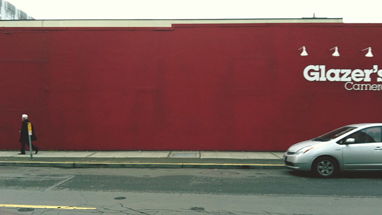 transportation, street, text, road, building exterior, architecture, communication, red, built structure, western script, road marking, road sign, men, land vehicle, information sign, guidance, mode of transport, walking