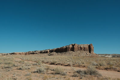 Scenic view of desert against clear blue sky