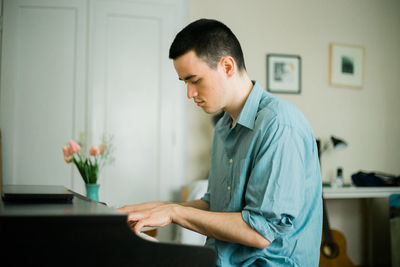 Side view of young man working at home