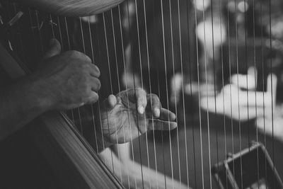 Cropped image of hands playing harp