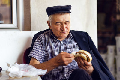 Senior man eating food at home