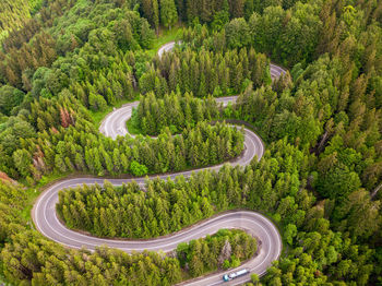 Winding road from high mountain pass, in summer time. aerial view by drone . romania