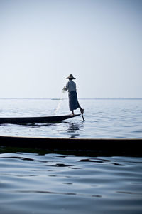 Man jumping in sea against clear sky