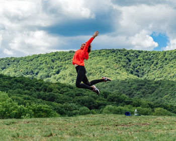 Full length of woman standing on field against sky