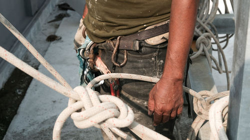 Low angle view of man working on rope
