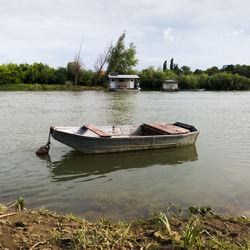 Boat moored in river against sky