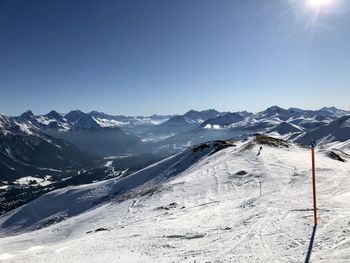 Scenic view of snowcapped mountains against clear blue sky