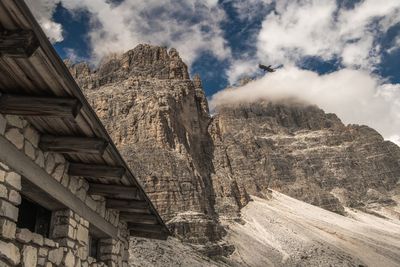 Low angle view of building and mountain against sky