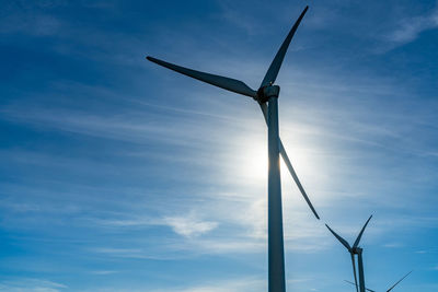 Low angle view of windmill against blue sky