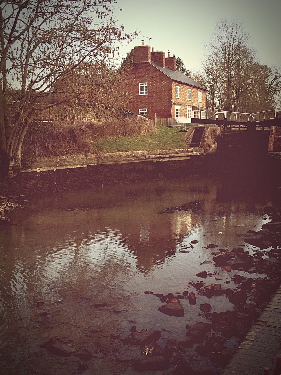 building exterior, architecture, built structure, water, tree, reflection, house, bare tree, waterfront, residential building, residential structure, river, lake, canal, sky, clear sky, city, building, outdoors, day