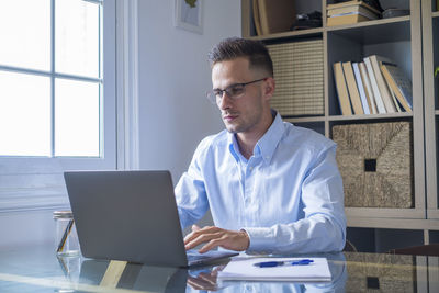 Businesswoman using laptop at desk in office