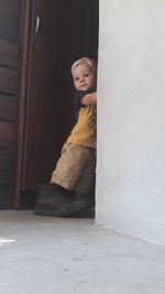 Full length of baby boy standing at doorway