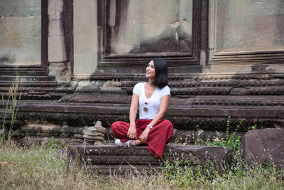 Full length of woman sitting on staircase