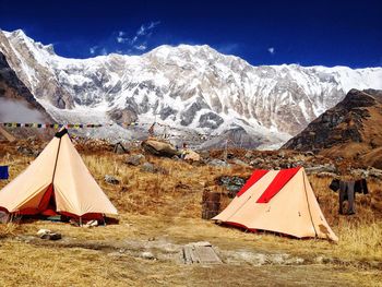 Panoramic view of tent and snowcapped mountains against sky