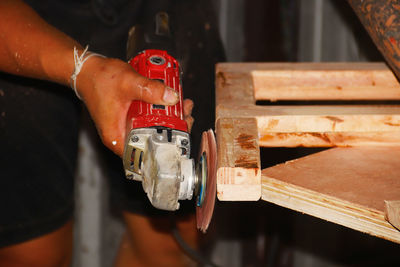 Midsection of man working on wood