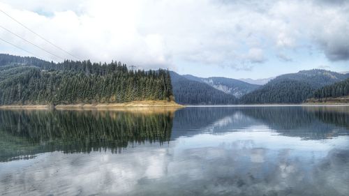 Reflection of trees in lake against sky