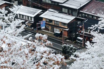 High angle view of snow covered houses amidst buildings