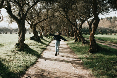 Rear view of woman walking on field