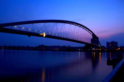 Suspension bridge over river at dusk