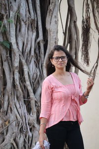 Full length of woman standing on tree trunk