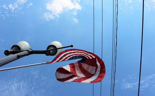 Low angle view of flag against blue sky
