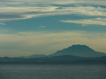 Scenic view of sea and mountains against sky during sunset